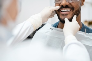 Dentist looking at the smiling mouth of patient in Bloomington IL