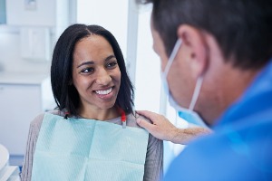 A dentist talks to a smiling woman about Teeth Bonding in McLean County IL