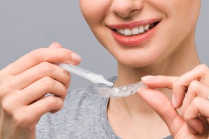 A woman uses the kit after inquiring about Take Home Whitening in Normal IL