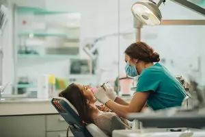A woman at the Dentist in Bloomington IL get her teeth checked out and cleaned.